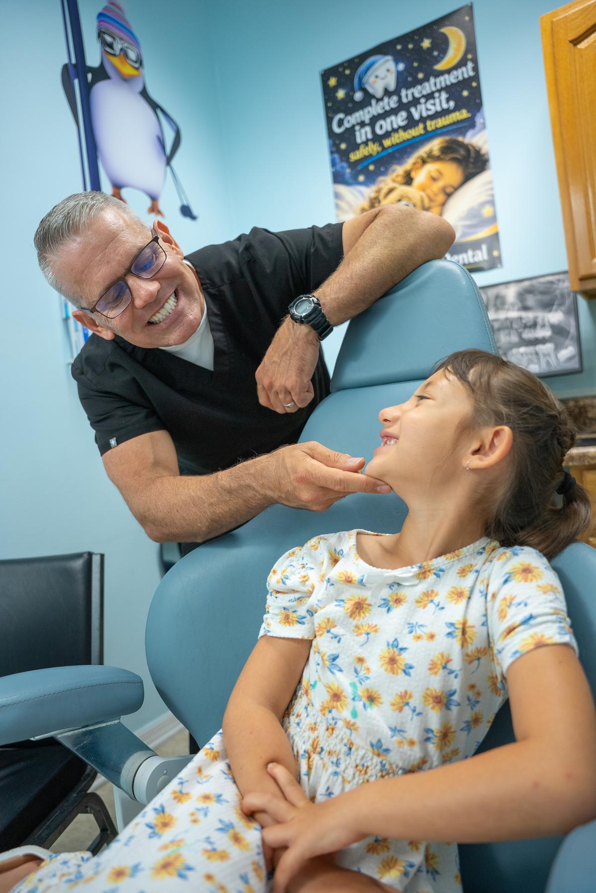 Dr. Pettinato smiling with a young patient in the dental chair at Cool Kid Dental in North Port